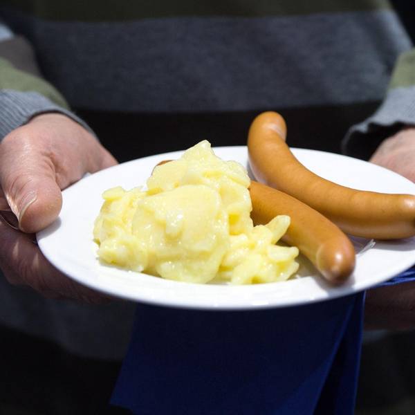 Kartoffelsalat und zwei Bockwürste auf einem Teller.