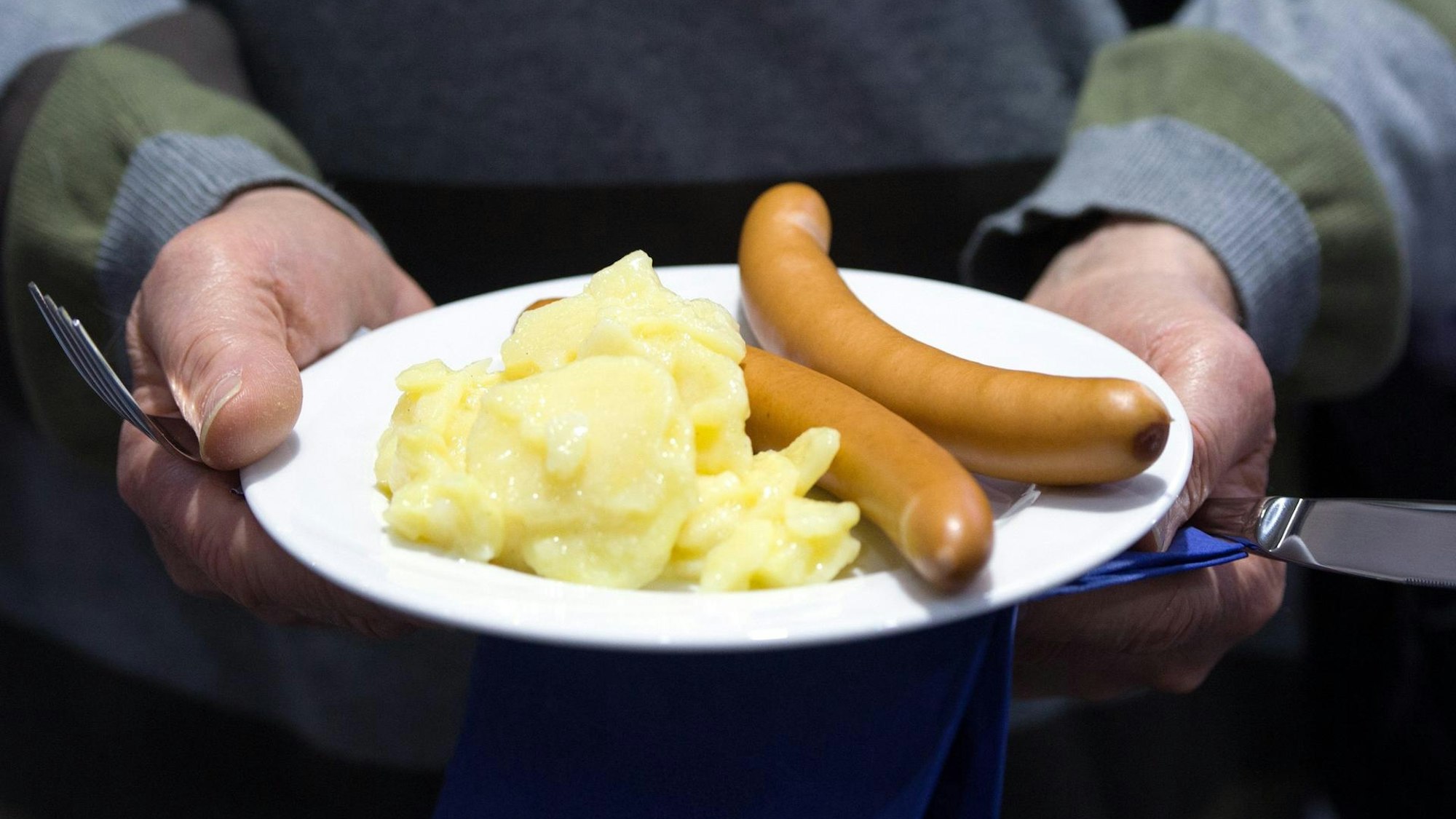 Kartoffelsalat und zwei Bockwürste auf einem Teller.
