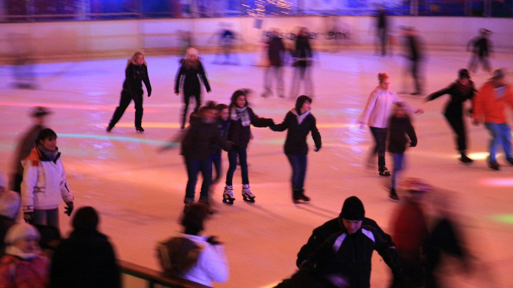 viele Menschen fahren mit Schlittschuhen auf einer Eisfläche