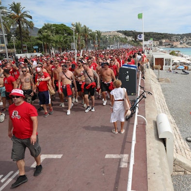 Fans marschieren am Strand vorbe
