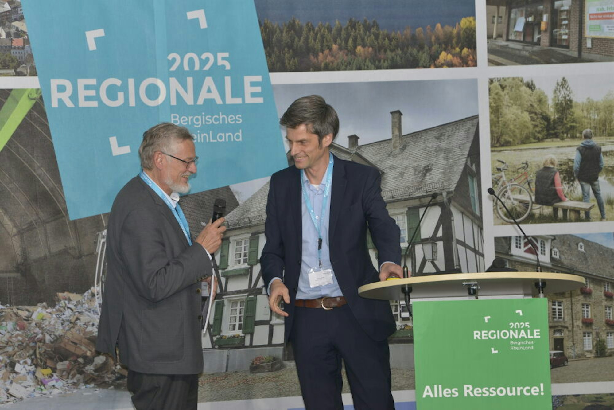 Prof. Michael Narodoslawsky (l.) und Thomas Kemme von der Regionale 2025-Agentur stehen auf einer Bühne und ziehen ein Fazit zur Veranstaltung.