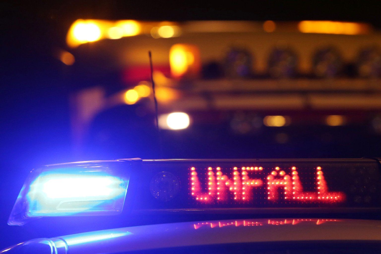 Die Polizei steht bei Nacht auf einer Straße.