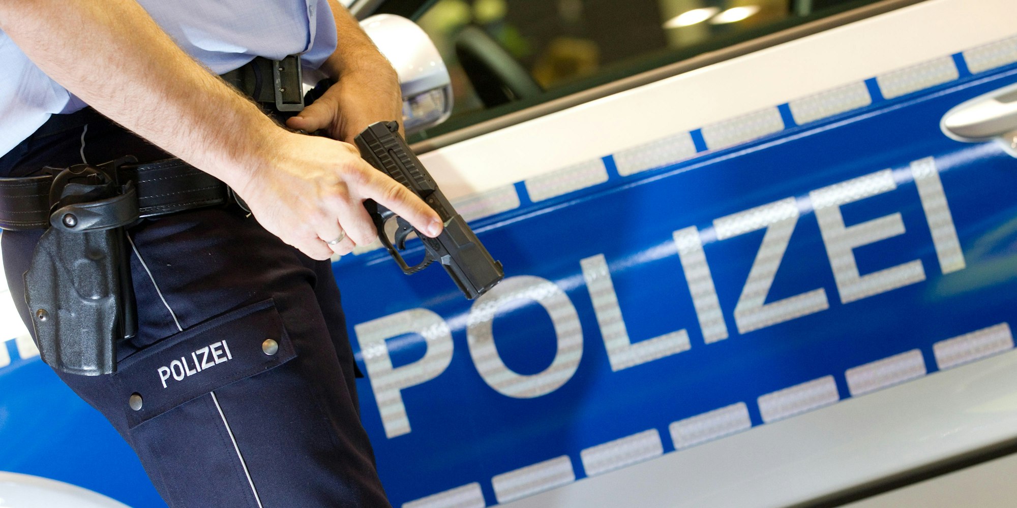 Polizist vor Polizeiauto