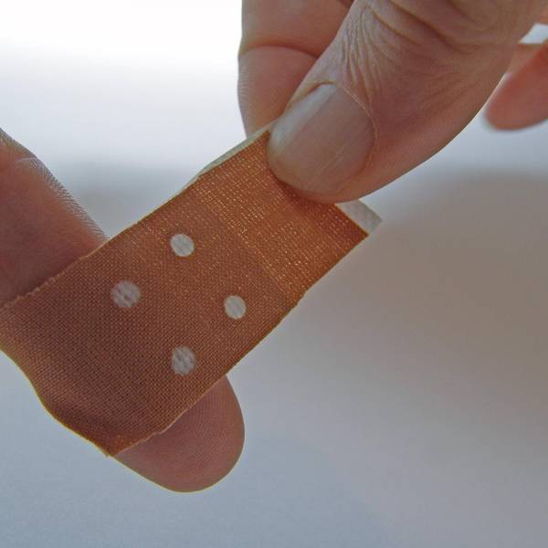 Pflaster_wird_um_Finger_nach_Papierschnitt_gewickelt
