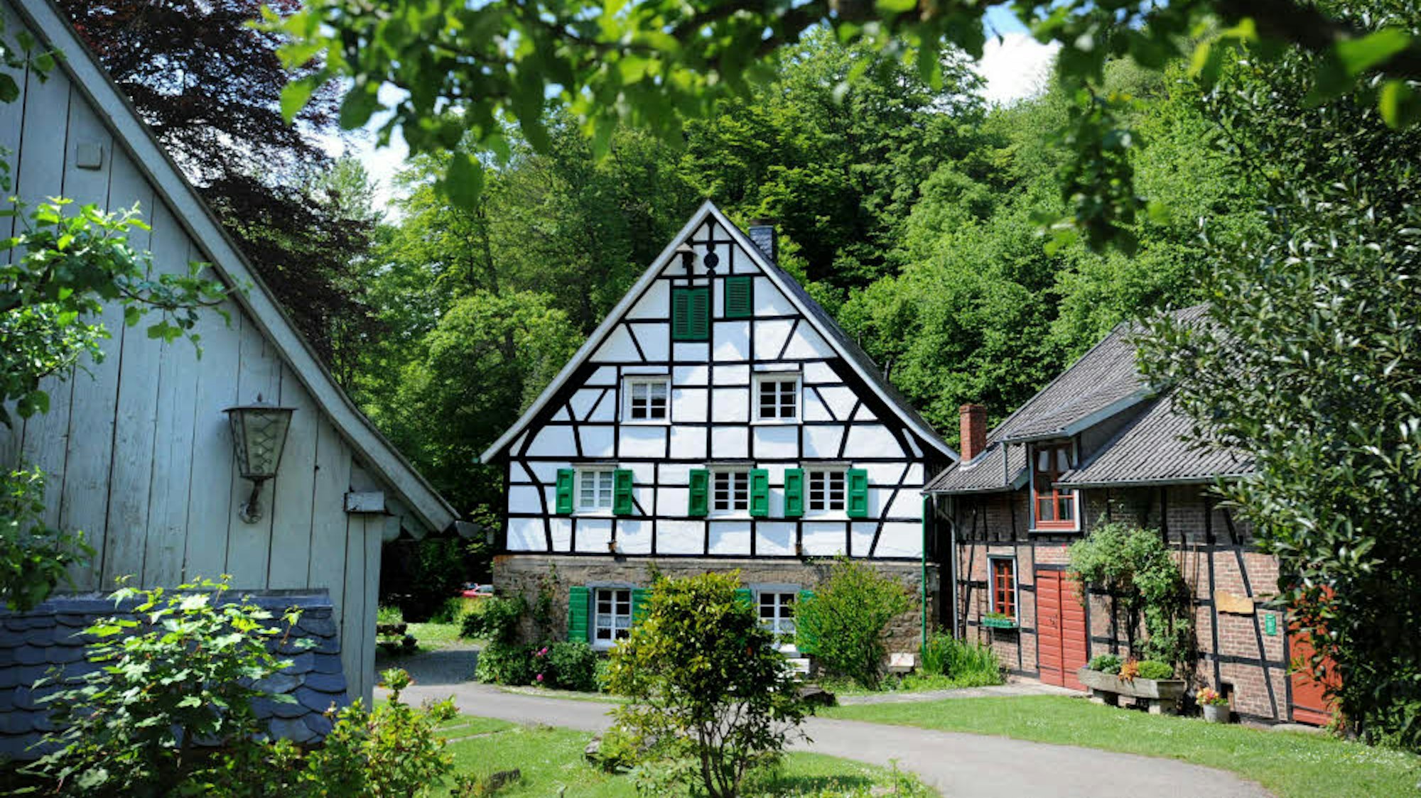 ein Weg führt auf einen Hof mit zwei Fachwerkhäusern