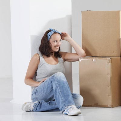 Frau neben Kartonstapel