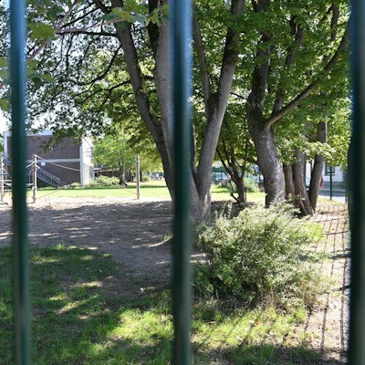 Ein Blick durch den Zaun auf das Gelämde der Grundschule In den Auen in Refrath.