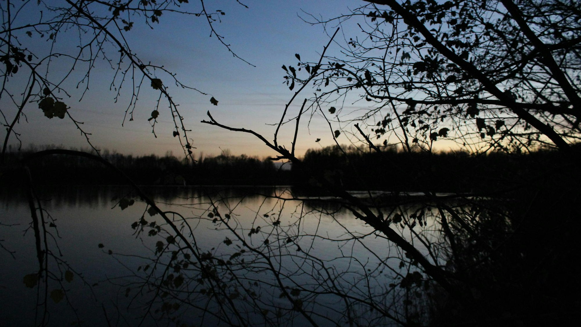 Blick auf einen See bei untergehender Sonne