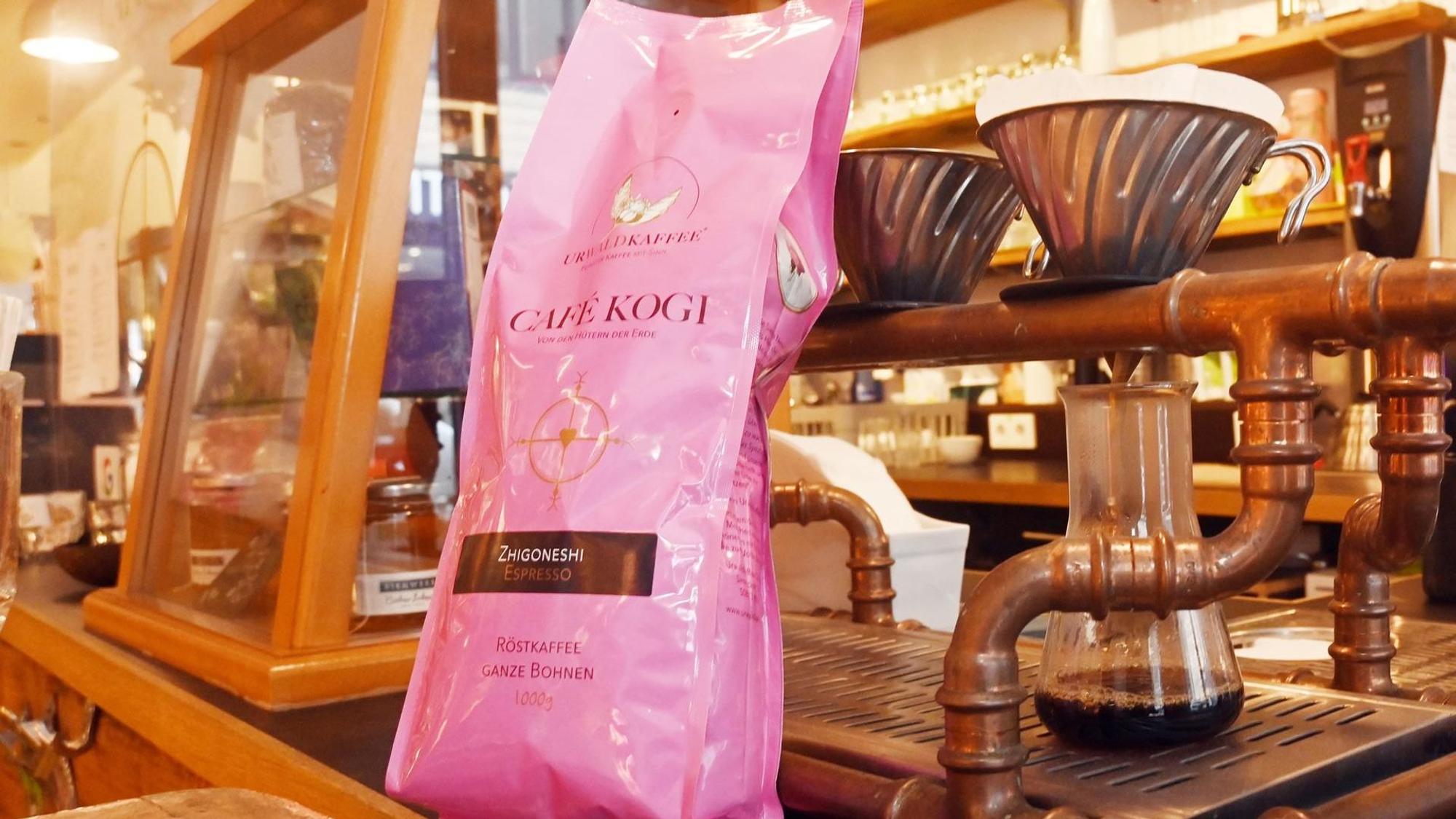 eine Packung Kaffee steht vor einer Kaffeemaschine
