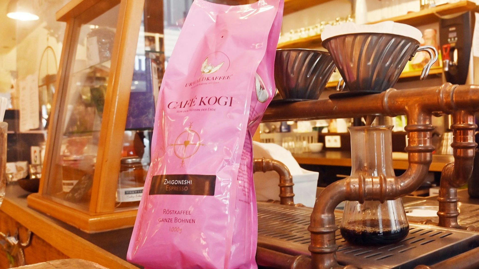 eine Packung Kaffee steht vor einer Kaffeemaschine