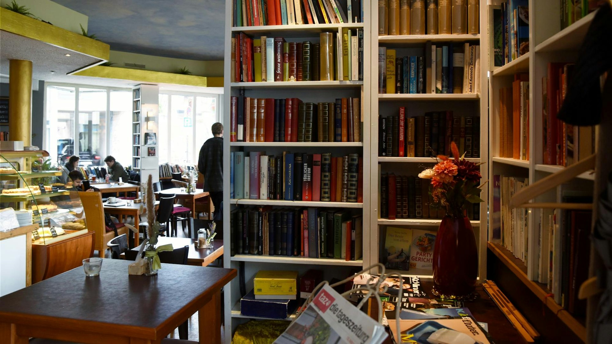 Bücherregale und Tische in einem Café.