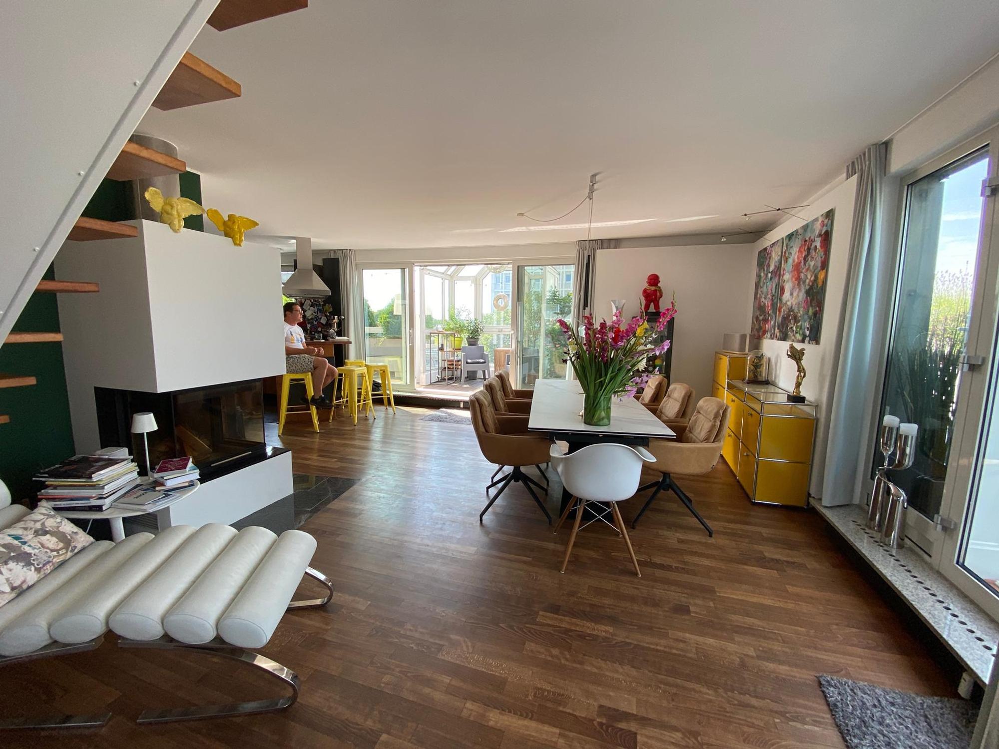 Der offene Wohnraum mit Kamin und großem Esstisch