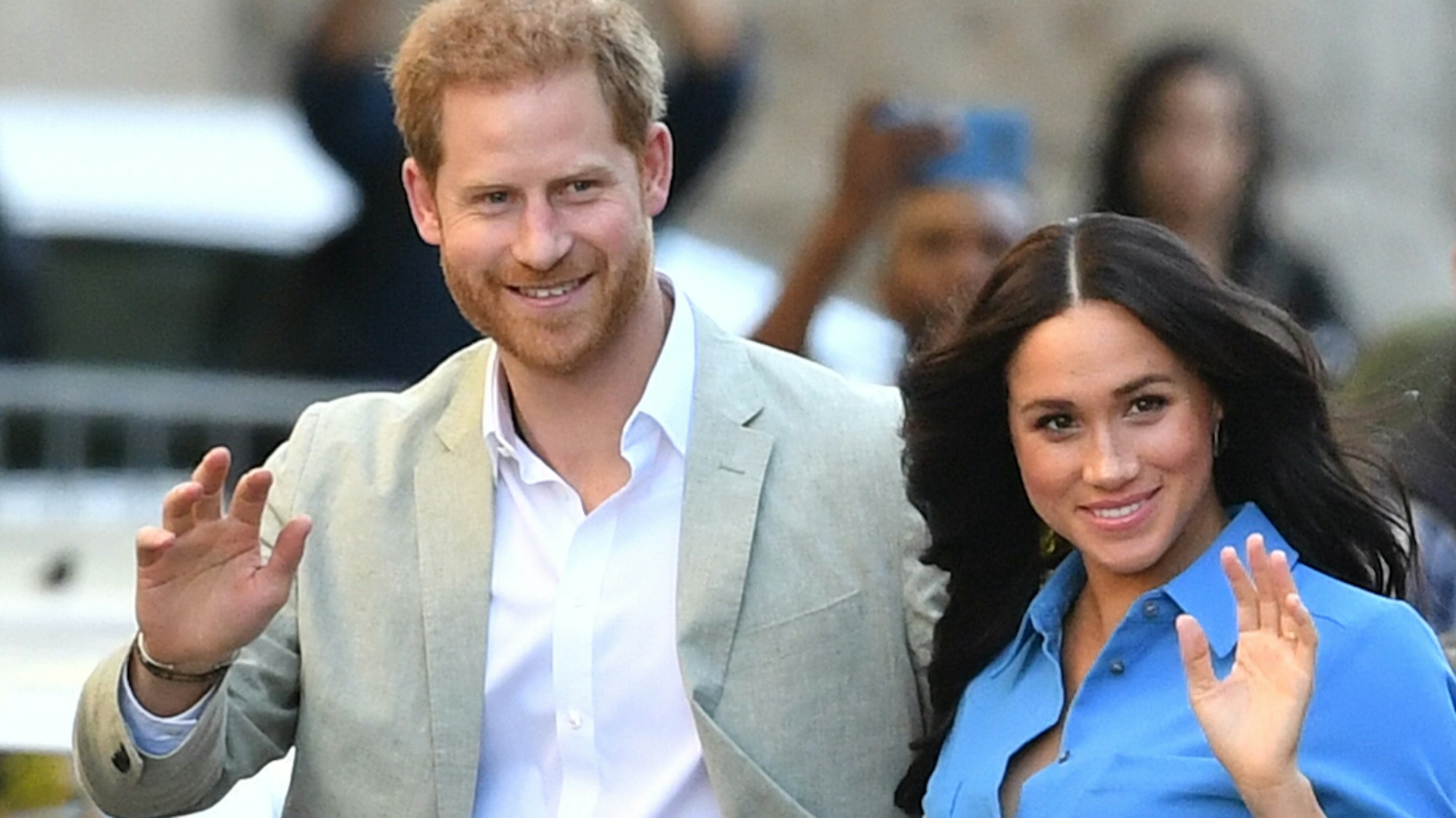 Prinz Harry und Herzogin Meghan winken bei einem öffentlichen Auftritt.