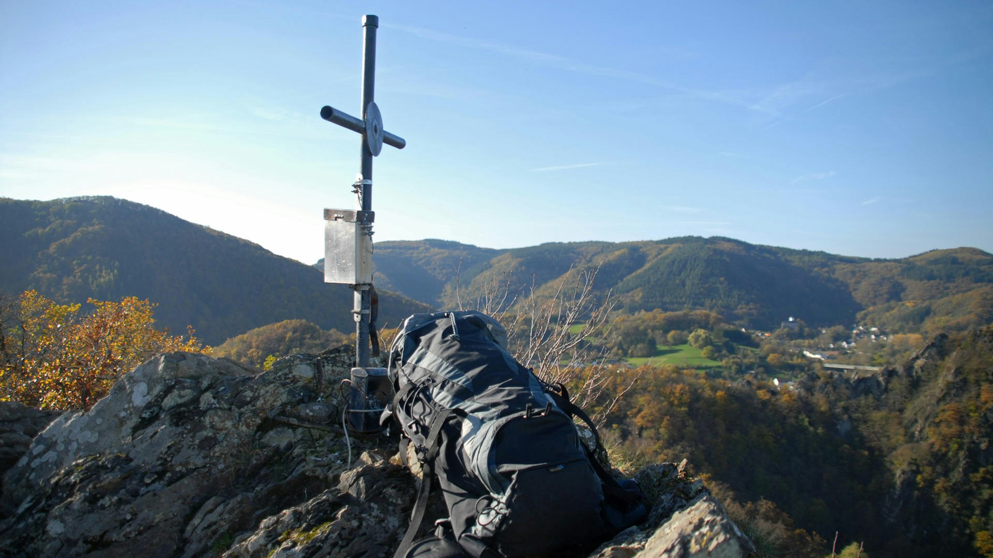 Gipfelkreuz auf Felsen mit Weitsicht über Berge