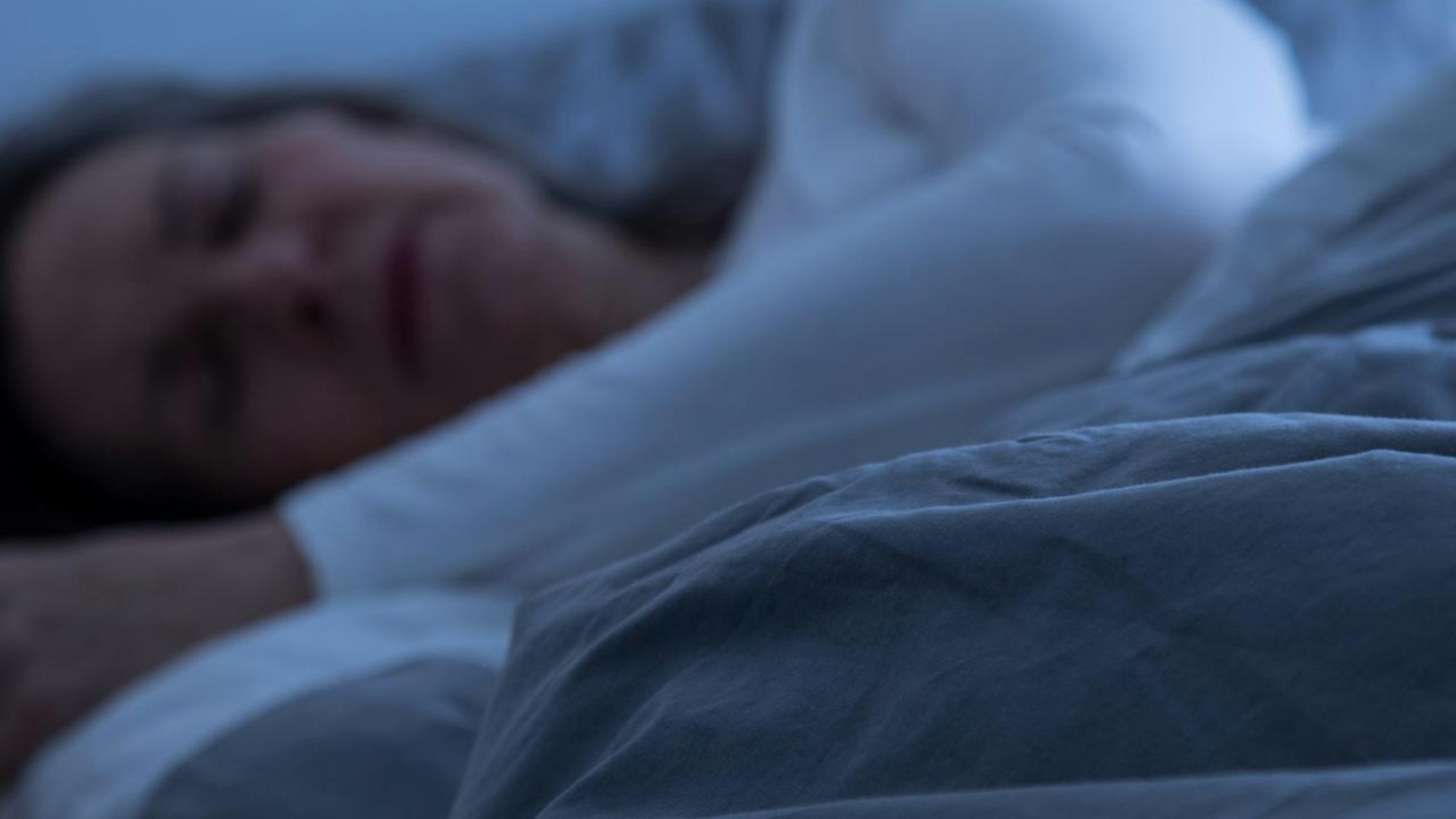 Frau liegt im Bett und schläft.