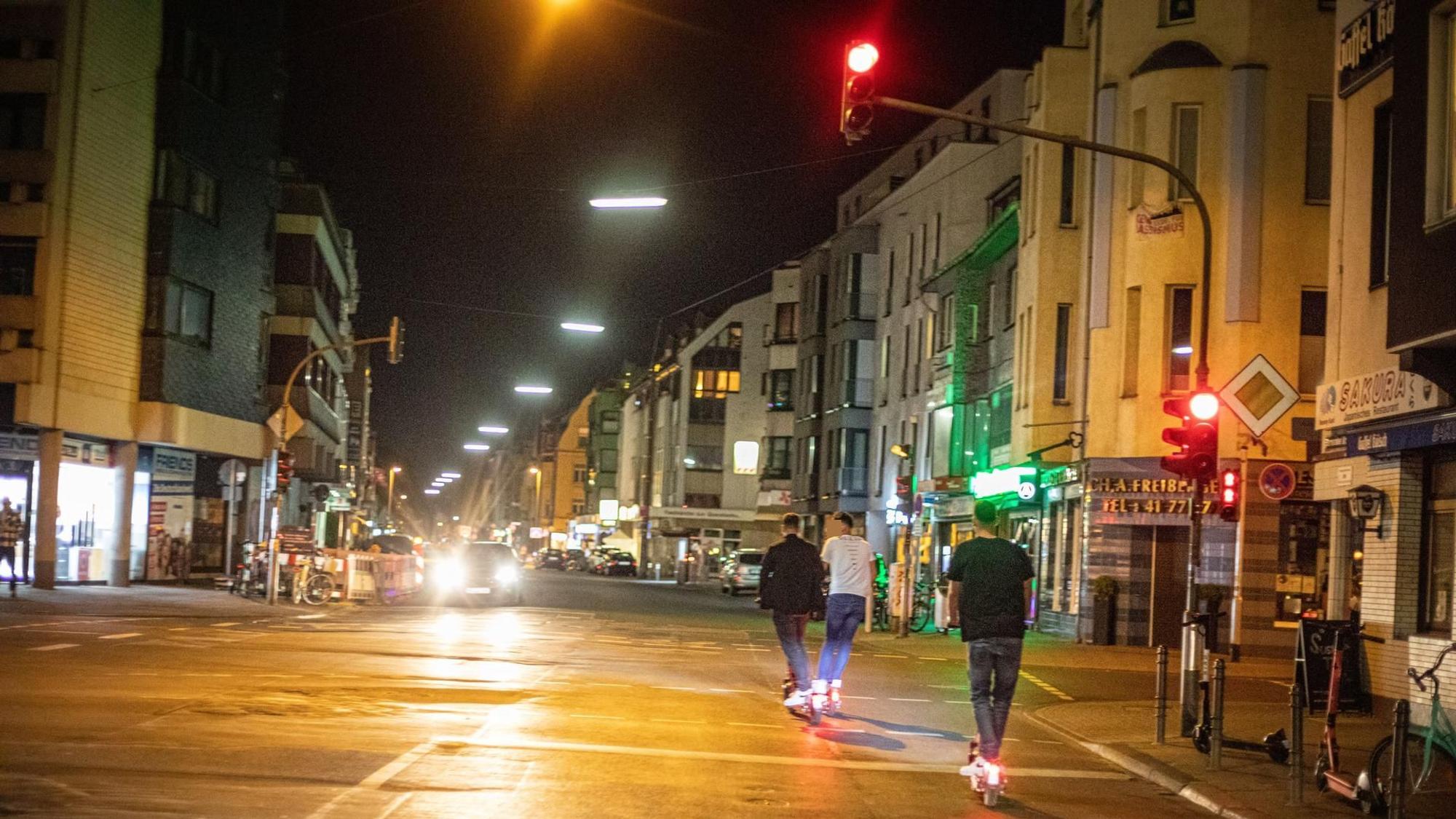 Drei Männer fahren auf E-Scootern.