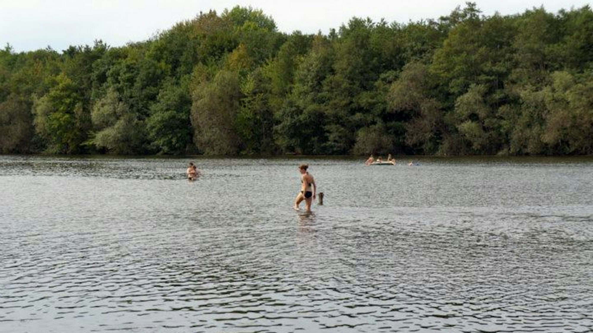 Im Heider Bergsee in Brühl geht eine Frau ins Wasser.