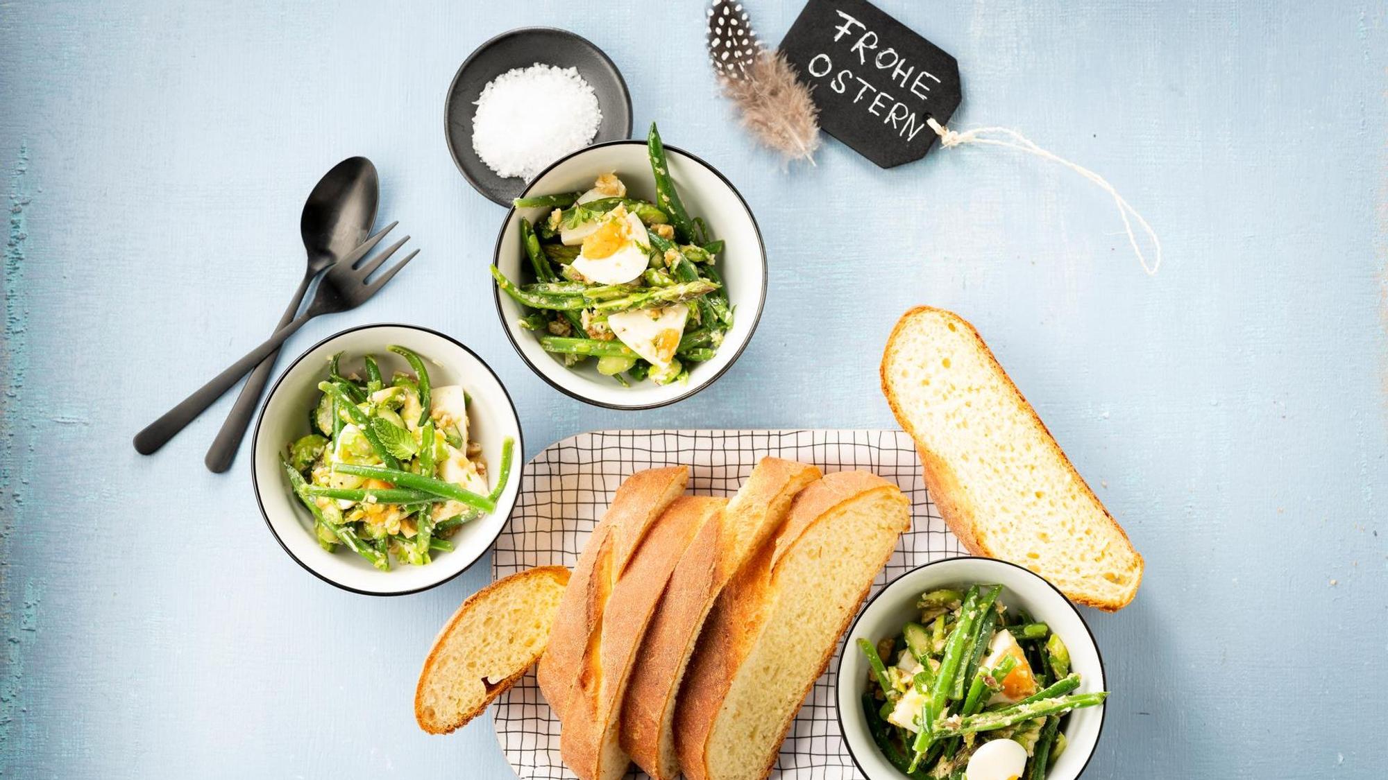 Eiersalat mit grünem Spargel in drei kleinen Schalen, daneben ein aufgeschnittenes Brot