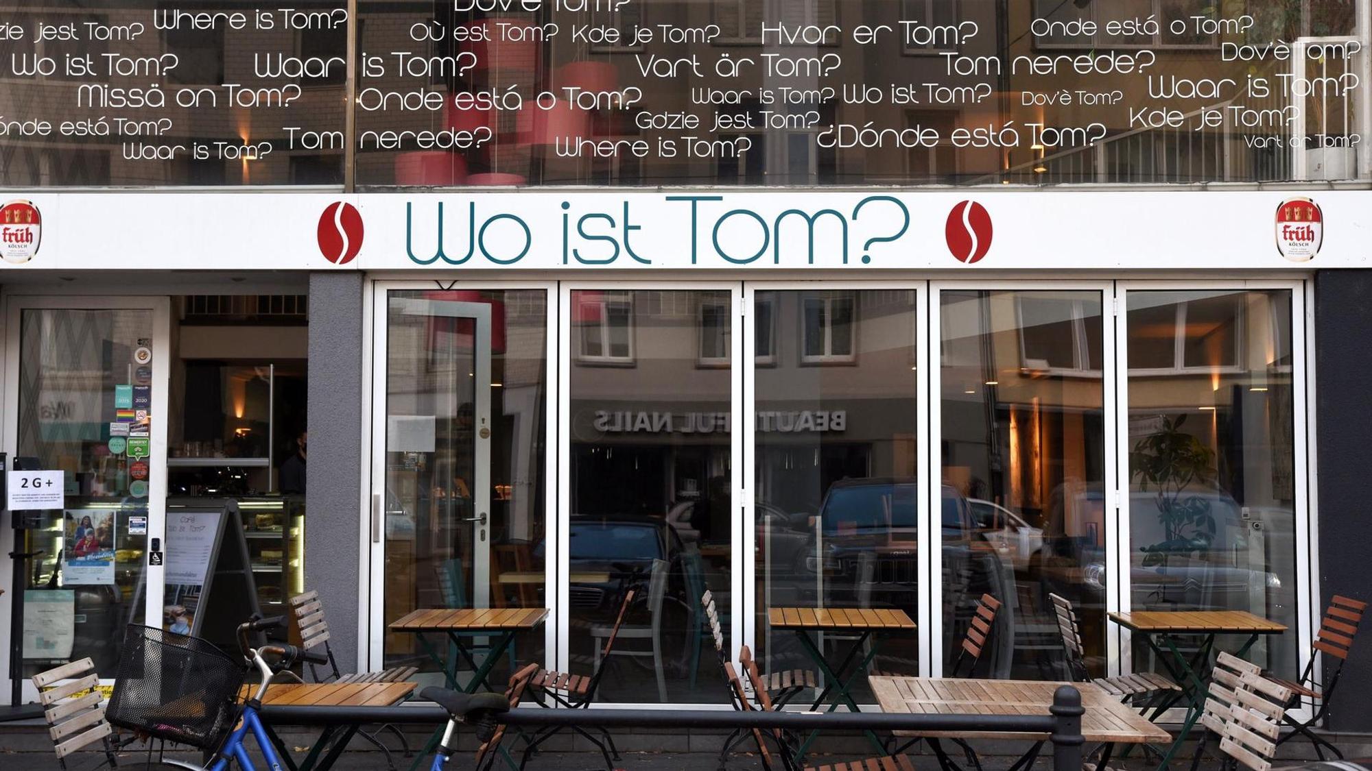 Tische und Stühle vor einem Café.