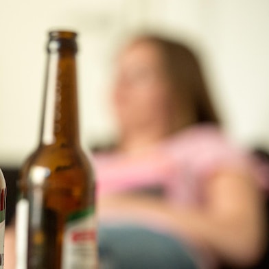 Frau mit Bierflaschen im Vordergrund