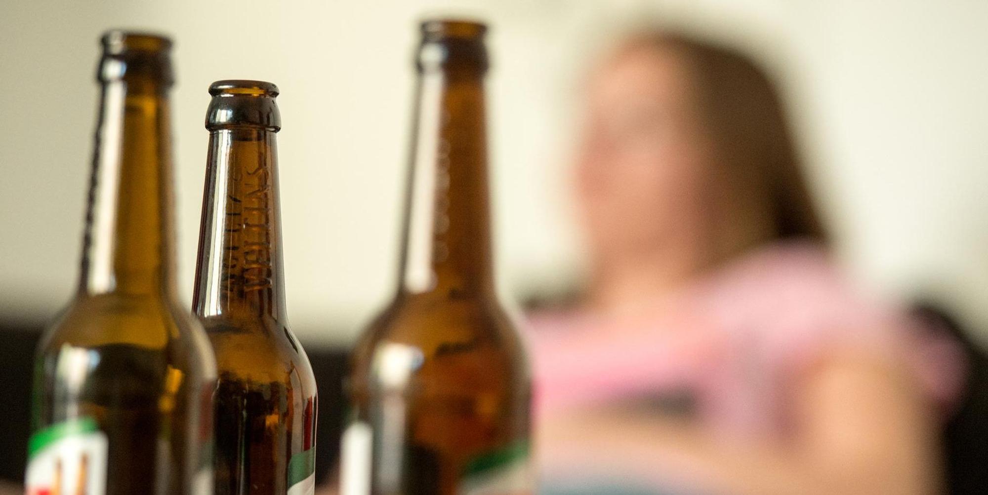 Frau mit Bierflaschen im Vordergrund