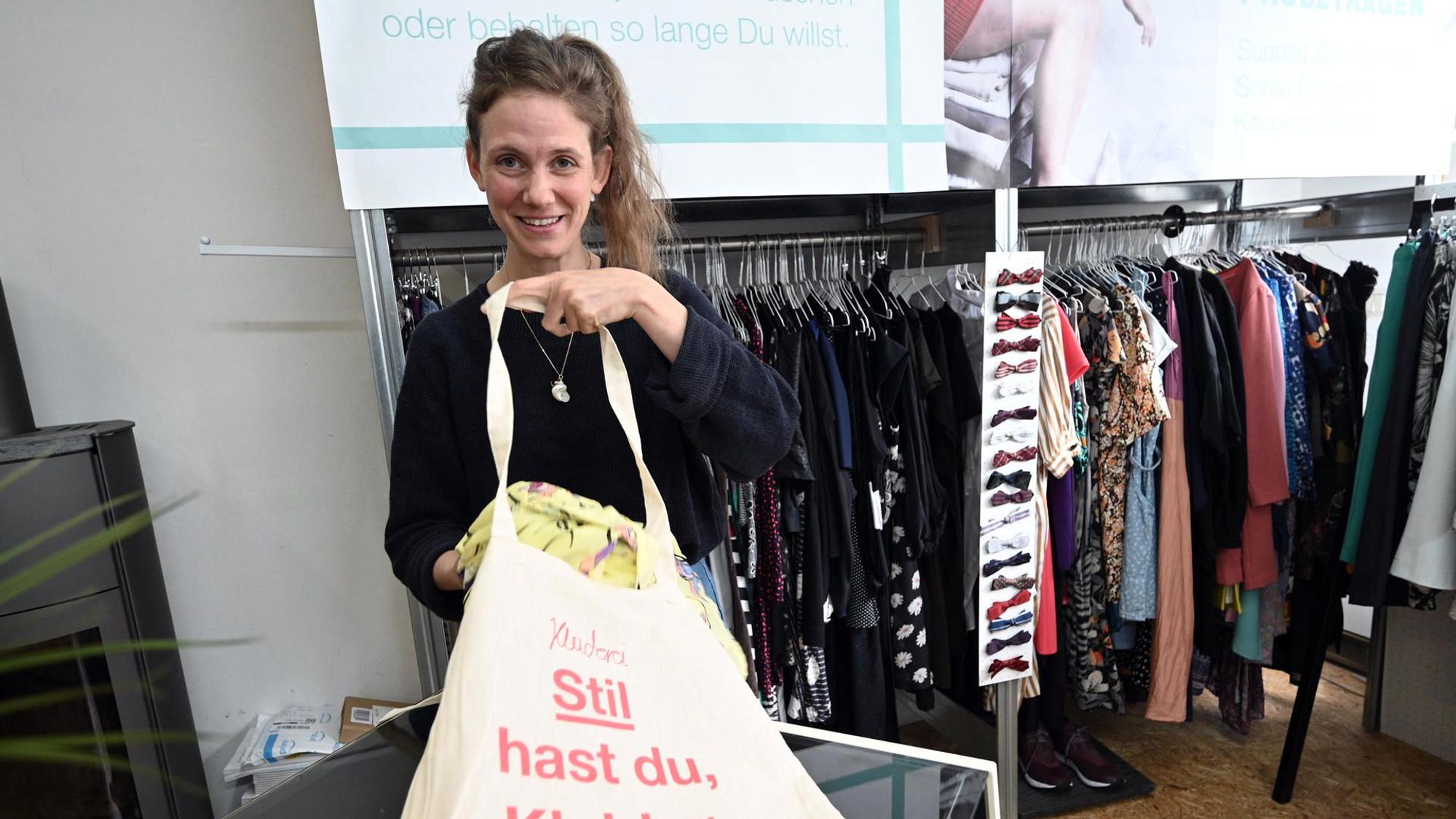eine Frau legt Kleidung in einen Jutebeutel