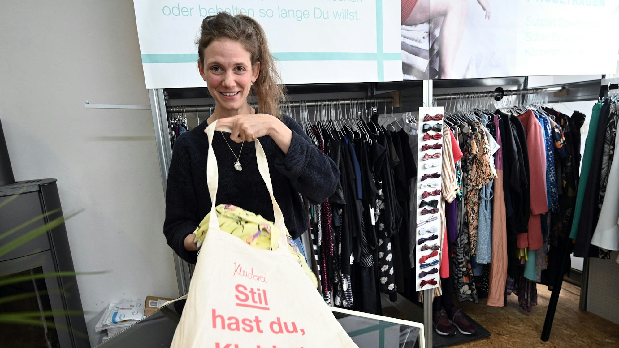 eine Frau legt Kleidung in einen Jutebeutel