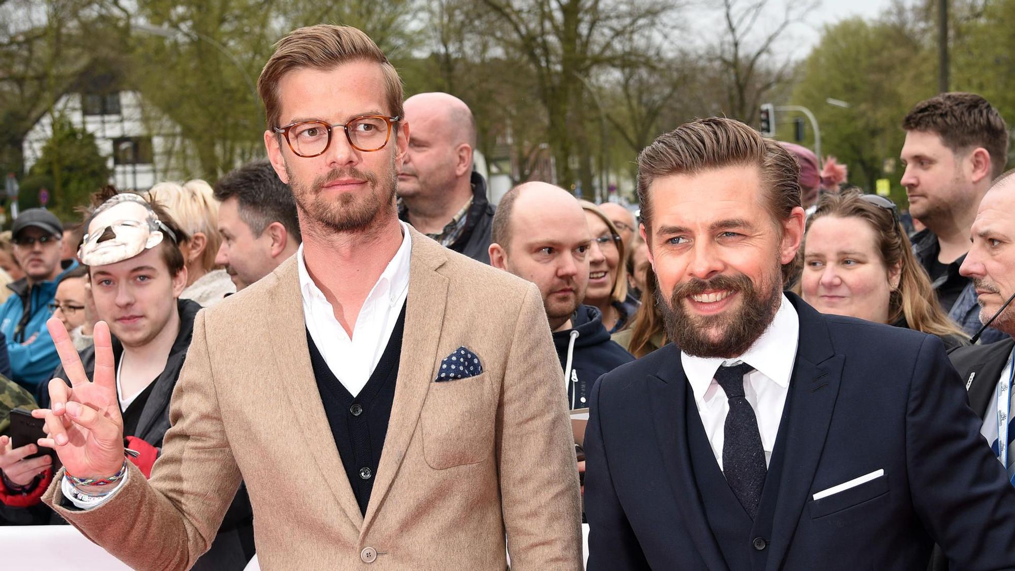 Joko Winterscheidt und Klaas Heufer-Umlauf bei einem öffentlichen Termin. Hinter ihnen stehen Fans. Joko macht das Peace-Zeichen. Klaas lacht.