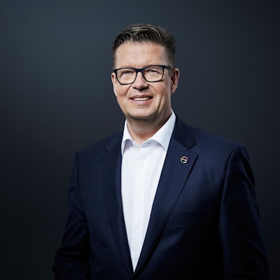 Klaus Schäfer im Anzug mit Brille vor schwarzem Hintergrund.