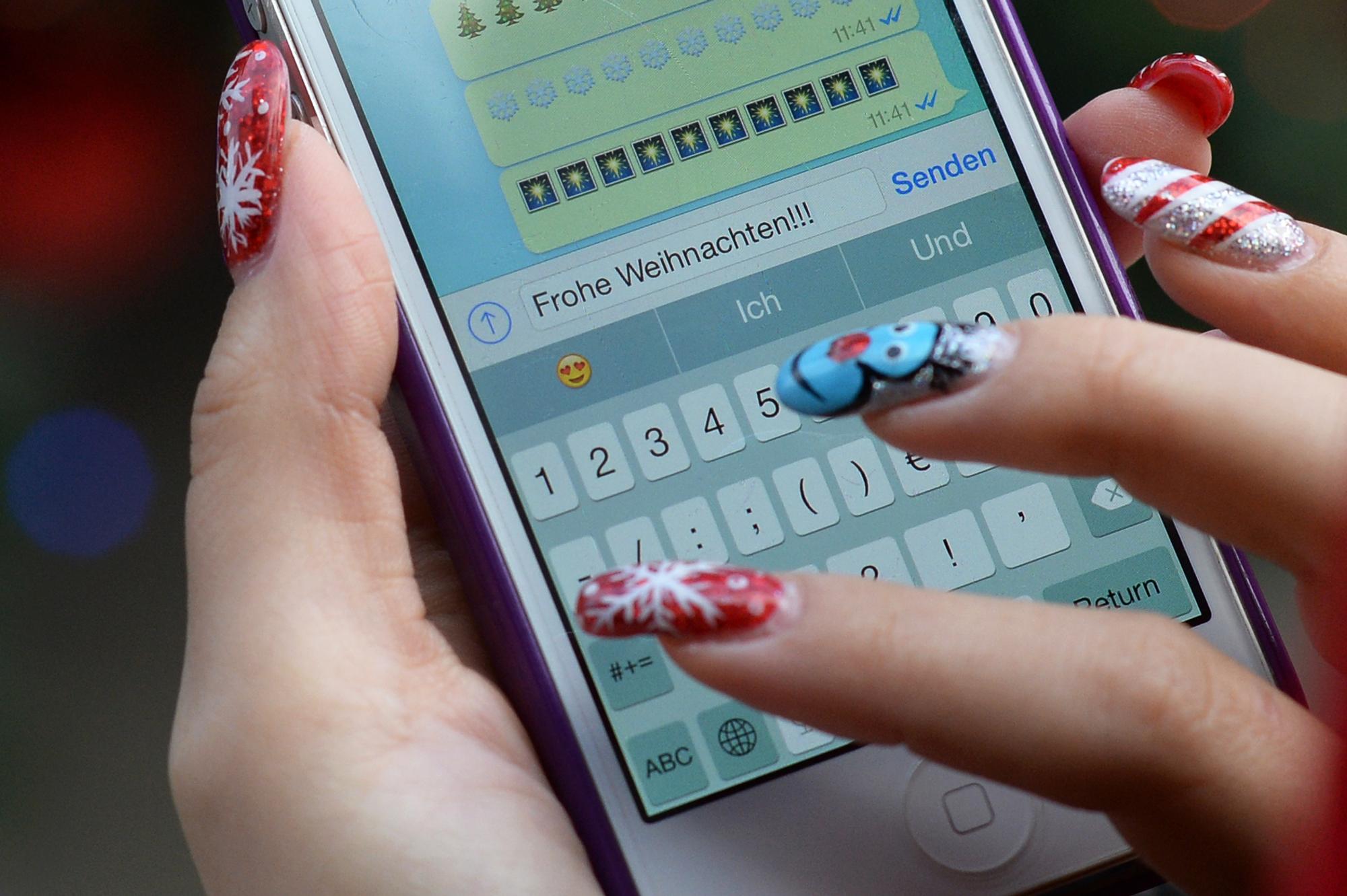 Frau-tippt-Frohe-Weihnachten-auf-einem-Smartphone-Whatsapp