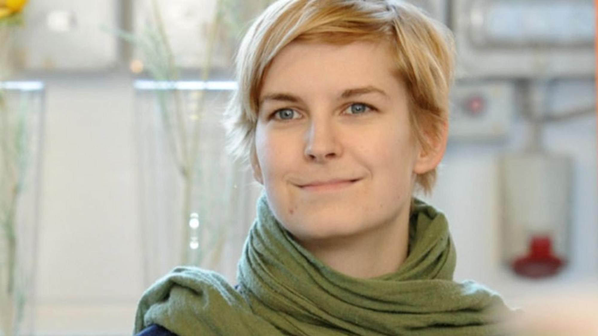 Natalie Kühn lächelt, hinter ihr ist ein Technikraum zu erkennen.