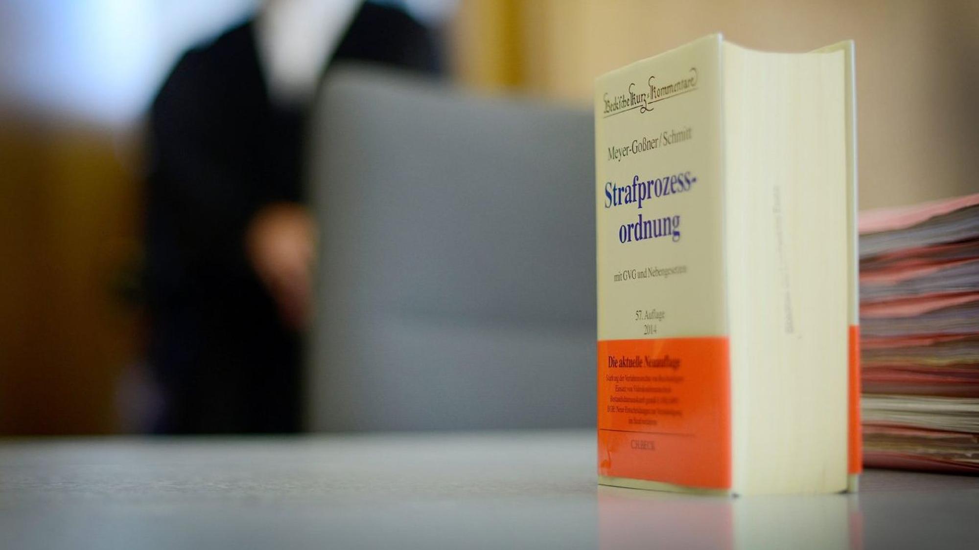Ein Buch mit der Strafprozessordnung steht auf einem Tisch.