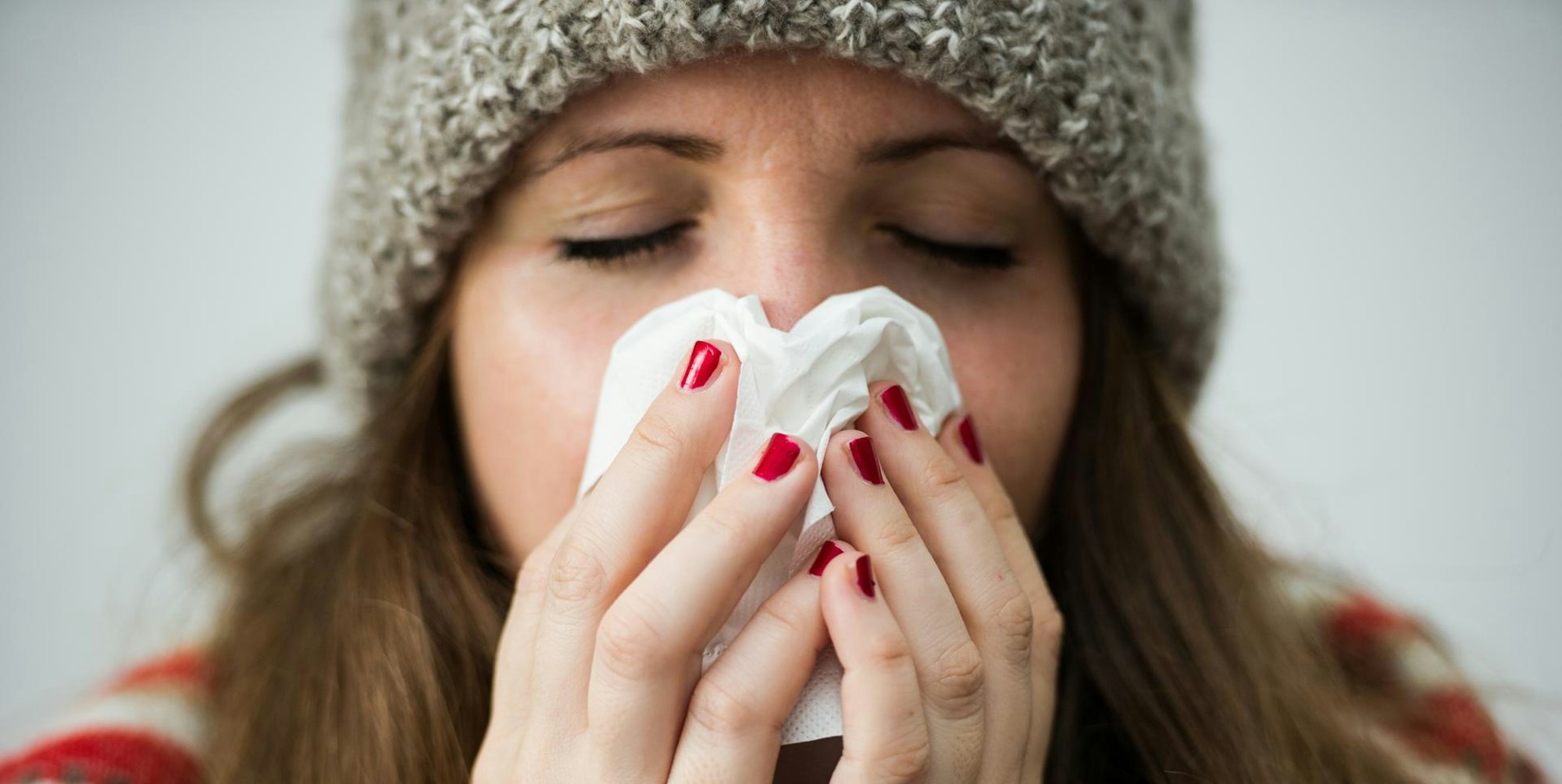 Frau putzt sich die Nase