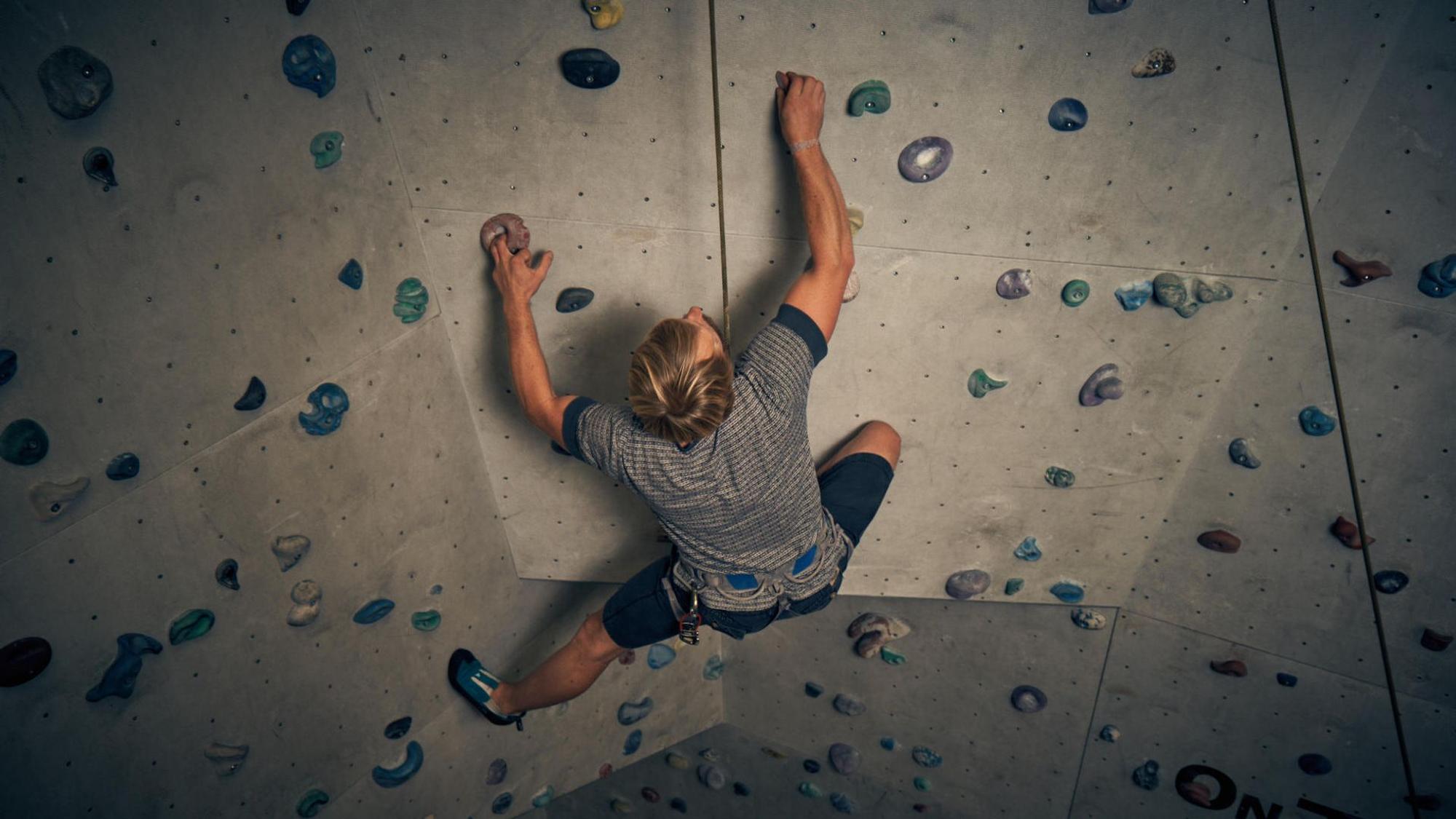 In den AbenteuerHallen Kalk klettert eine Person an einer Kletterwand.