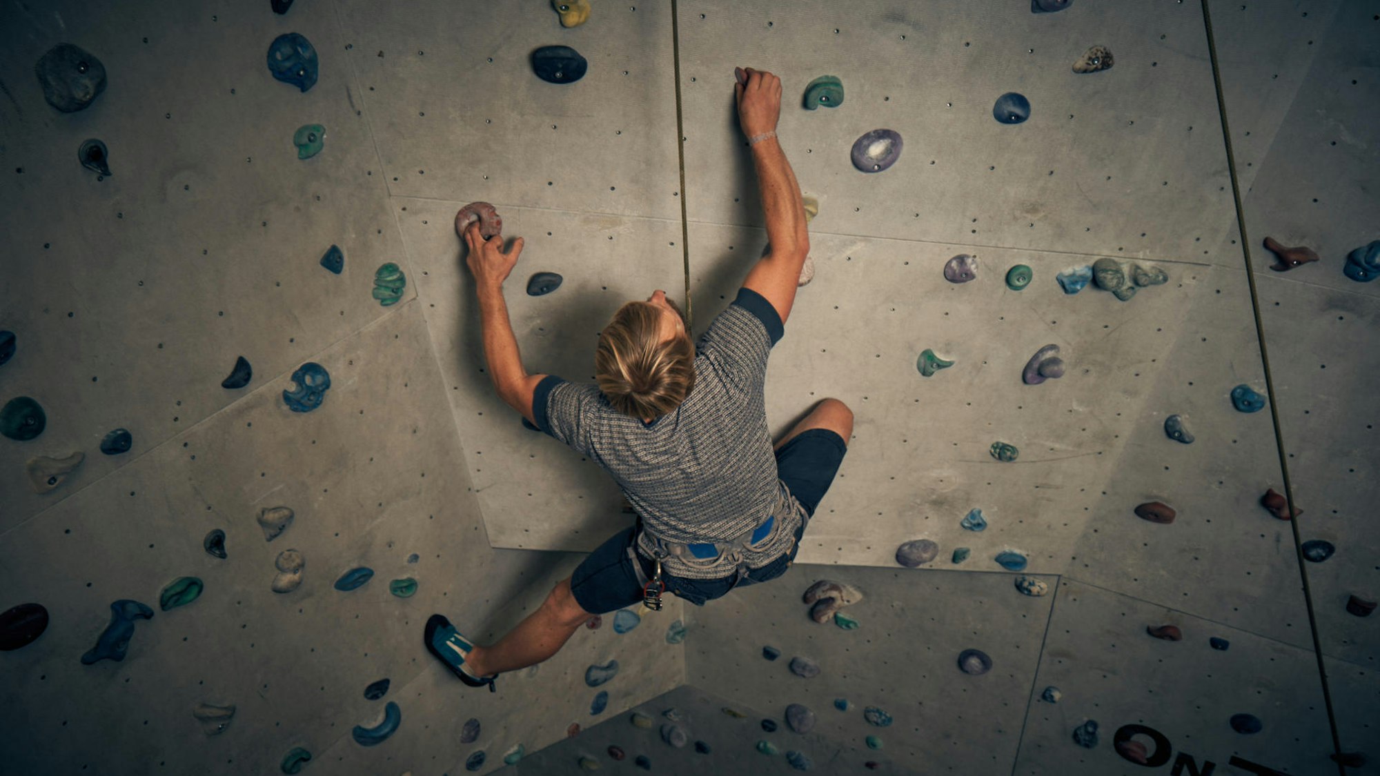 In den AbenteuerHallen Kalk klettert eine Person an einer Kletterwand.