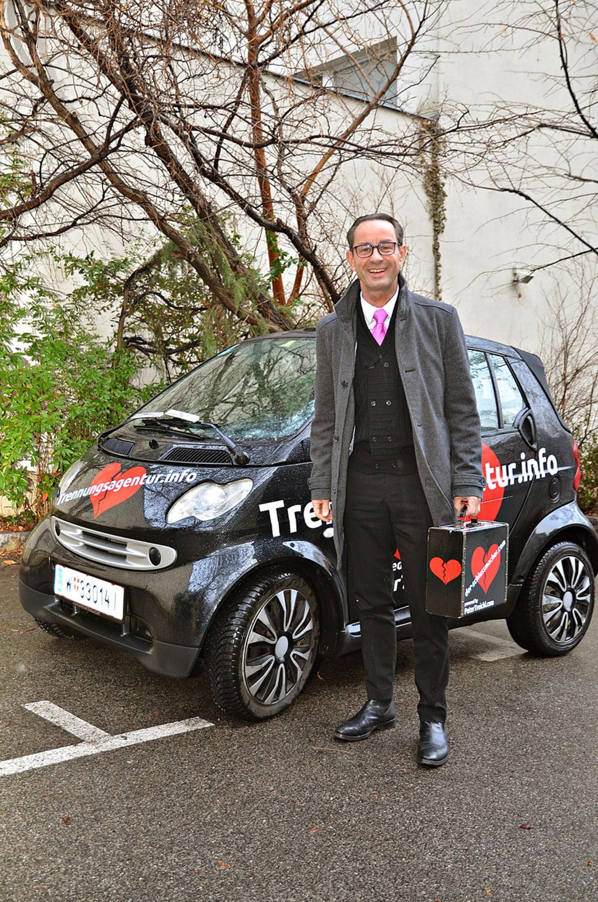 Trennungsagentur Herr Treichel vorm Smart mit Koffer