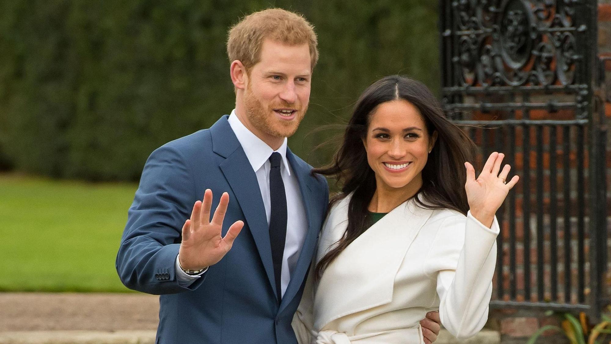 Harry und Meghan winken Fotografen zu.