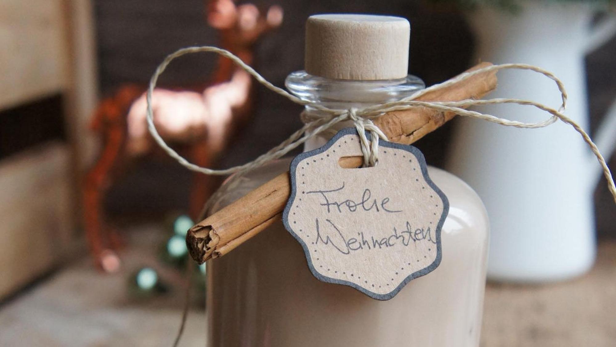 Likör in einer Flasche mit Zimtstange dekoriert