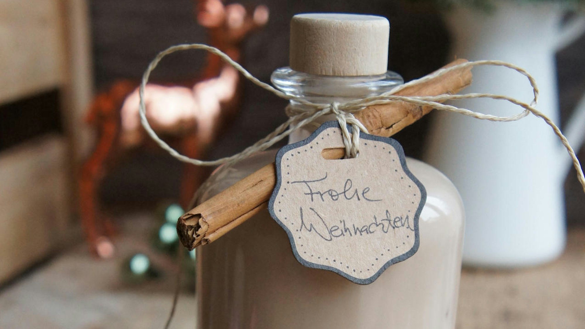 Likör in einer Flasche mit Zimtstange dekoriert