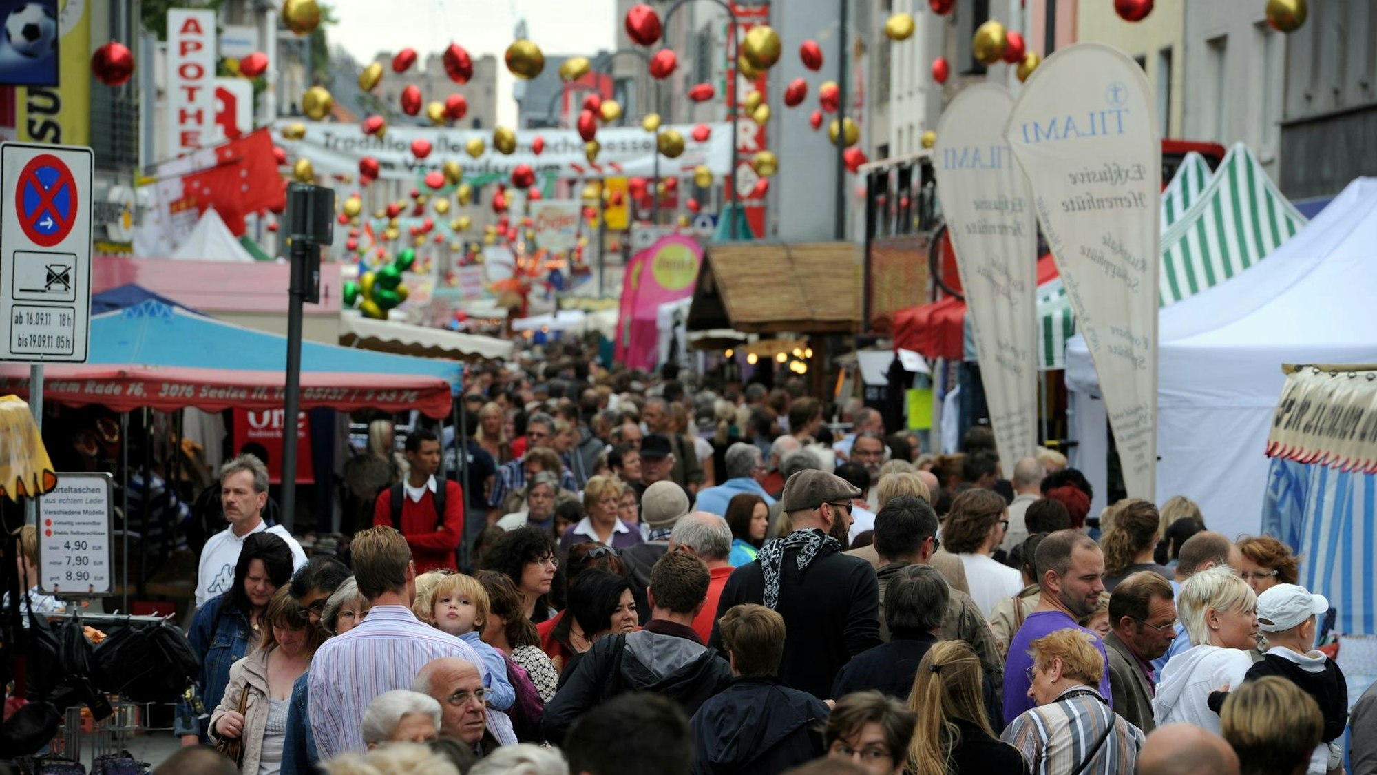Die Straße beim „Dä längste Desch vun Kölle“ mit Buden und Menschen.