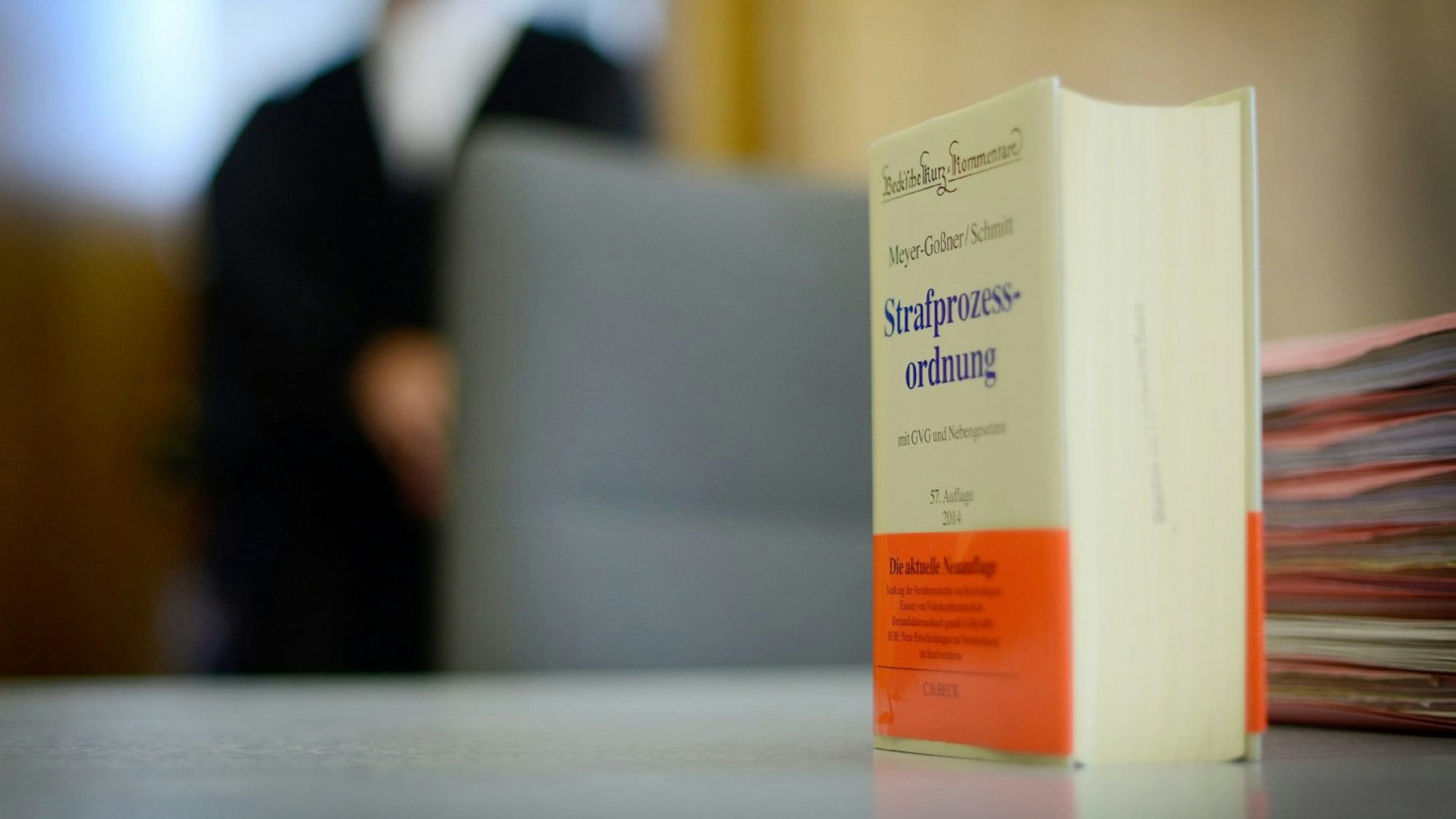 Das Buch der Strafprozessordnung steht auf einem Tisch in einem Gerichtssaal.