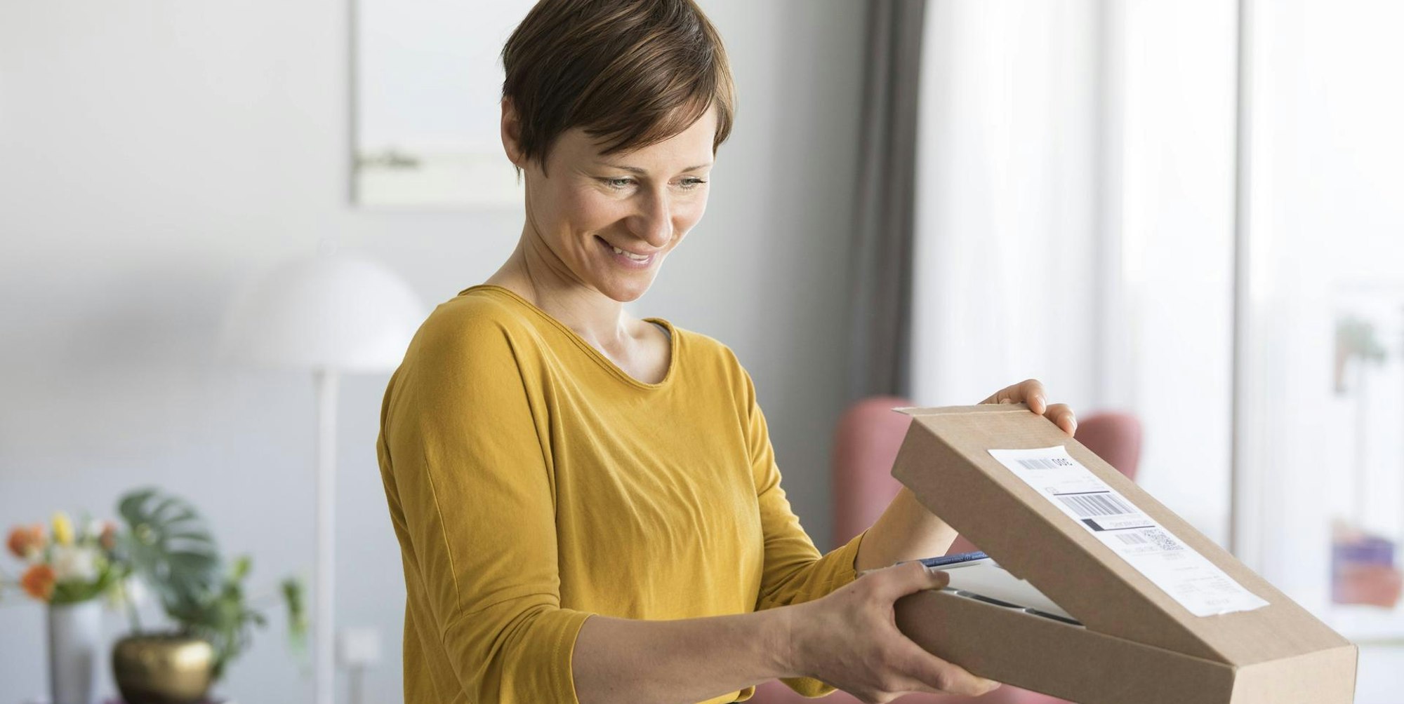 Frau_öffnet_Paket_Imago