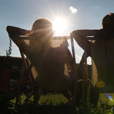 Mann und Frau sitzen in der Sonne und relaxen