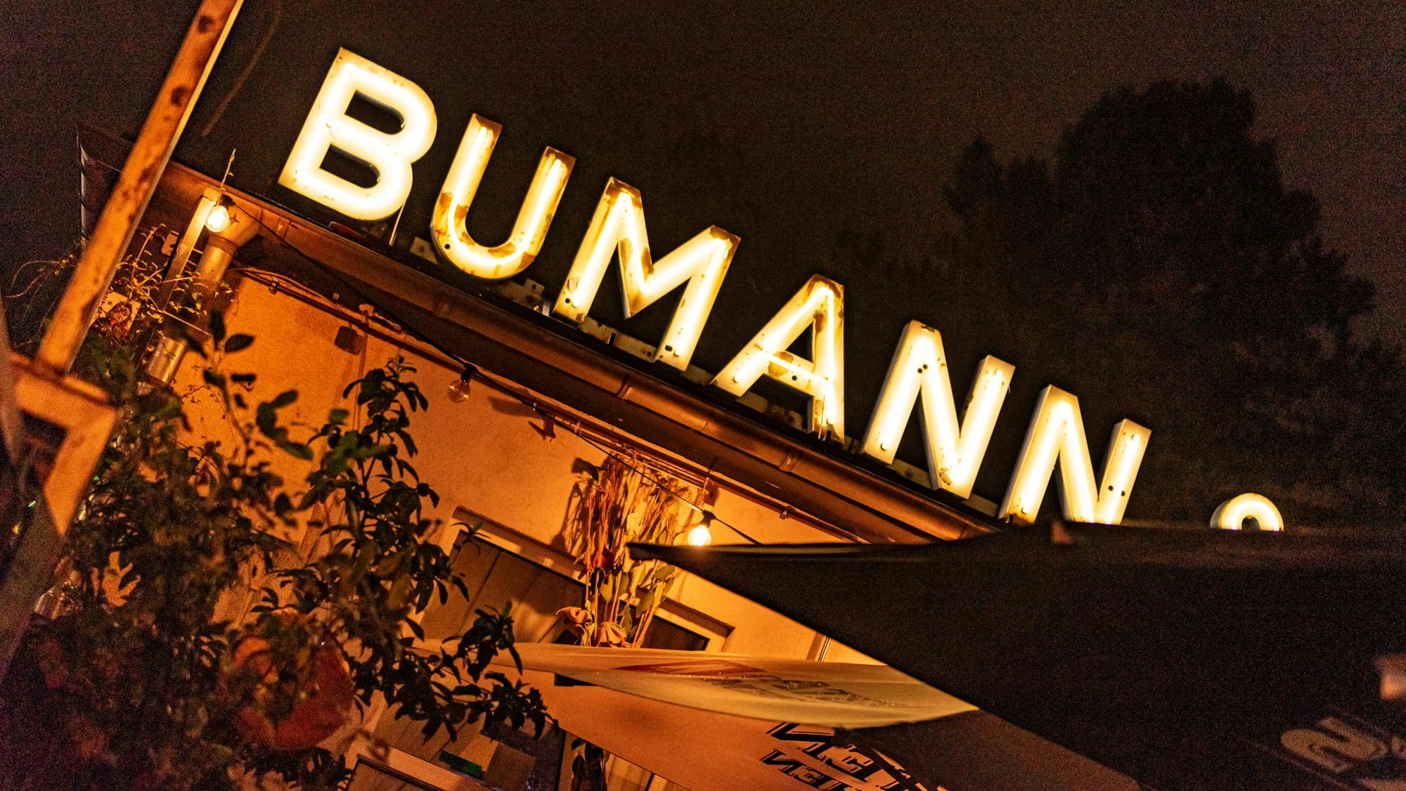 Der Biergarten im Bumann in Köln, zu sehen ist die Leuchtreklame.