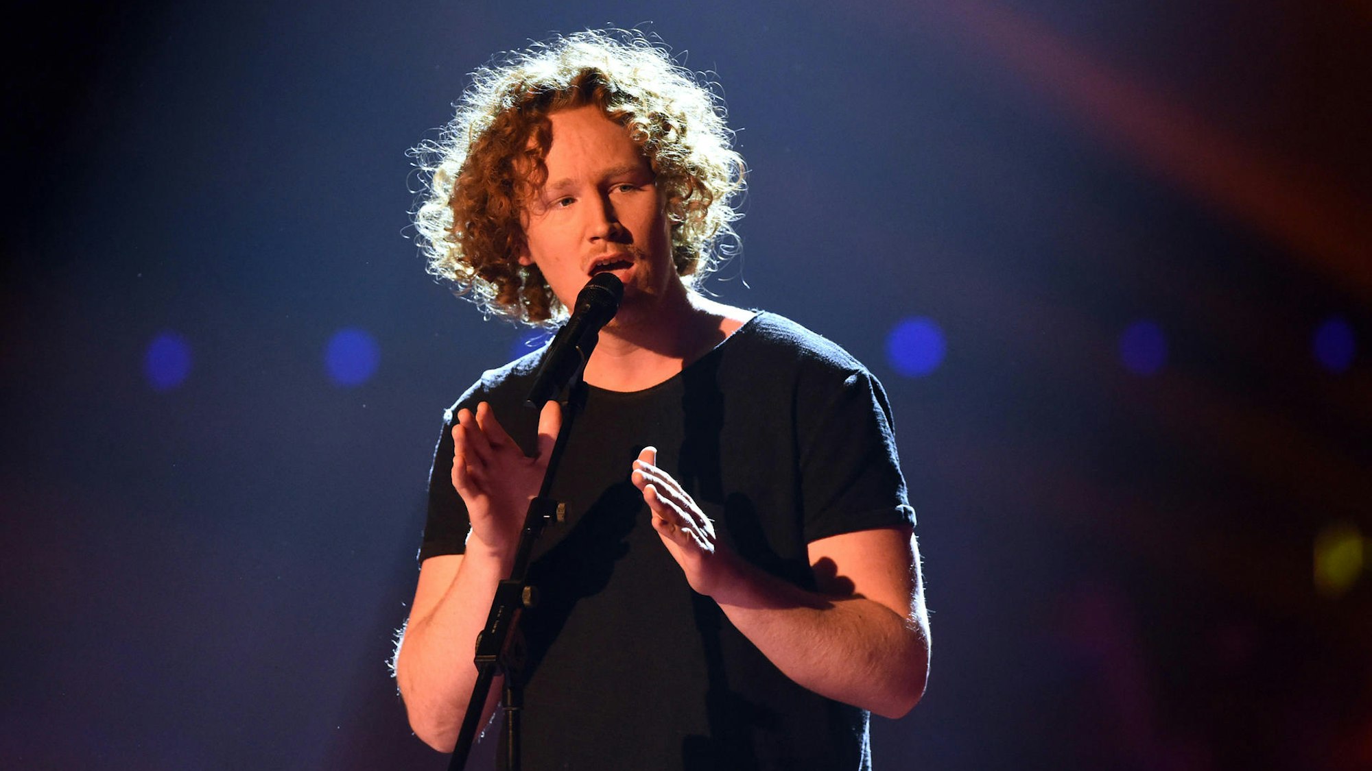 Michael Schulte singt in ein Mikro.