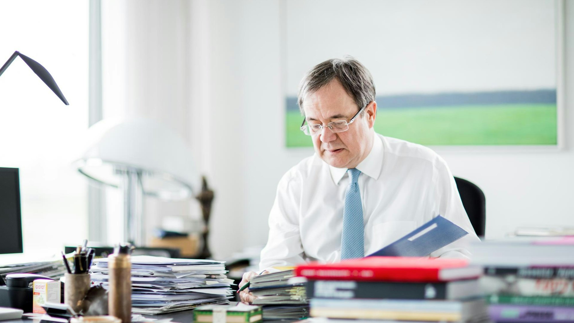 Armin Laschet studiert an seinem Schreibtisch in Düsseldorf Akten.
