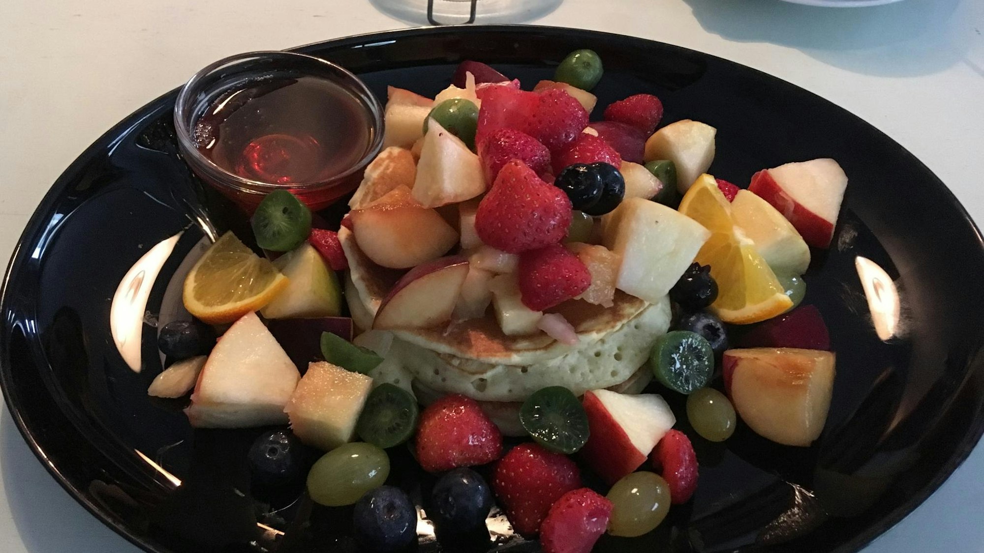 Pancakes, serviert auf einem Teller mit ganz viel Obst