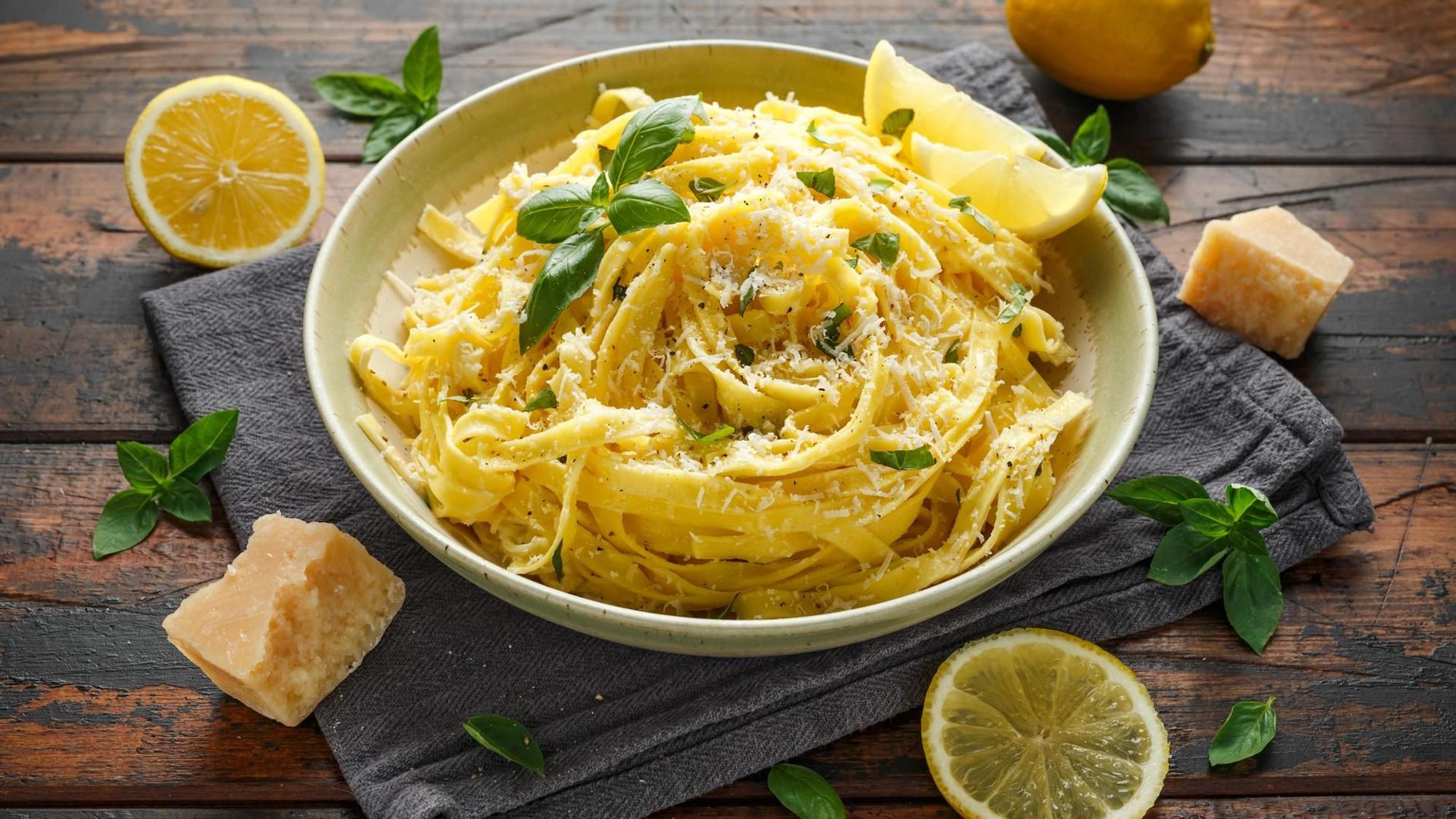 Zitronen-Pasta lecker serviert und angerichtet in einem tiefen Teller mit Zitronen als Deko