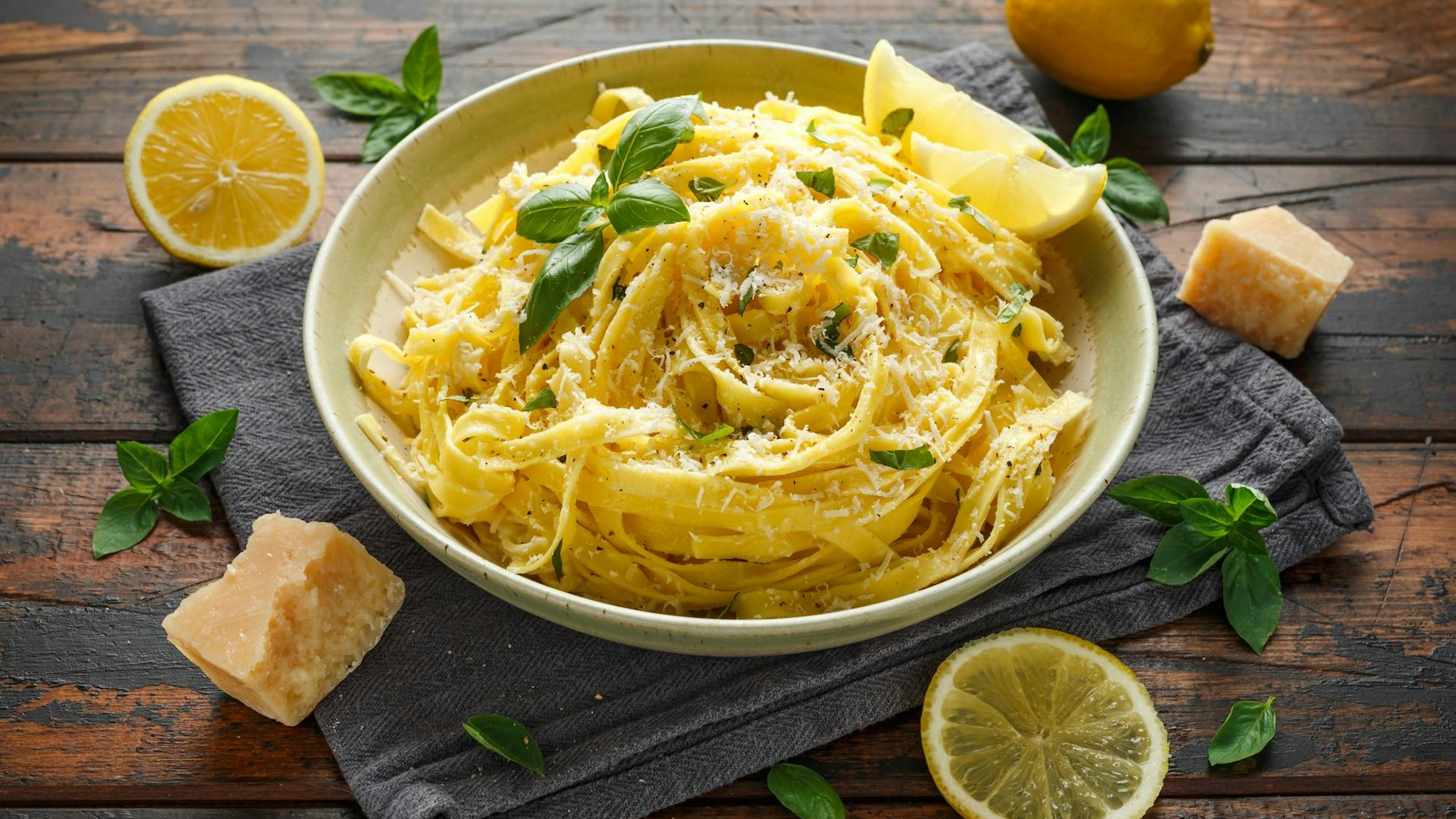 Zitronen-Pasta lecker serviert und angerichtet in einem tiefen Teller mit Zitronen als Deko