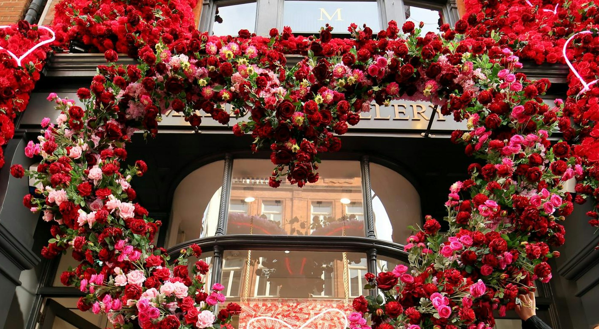 Eine Blumeninstallation an einem Fenster von einem Restaurant oder Laden. (Symbolbild)